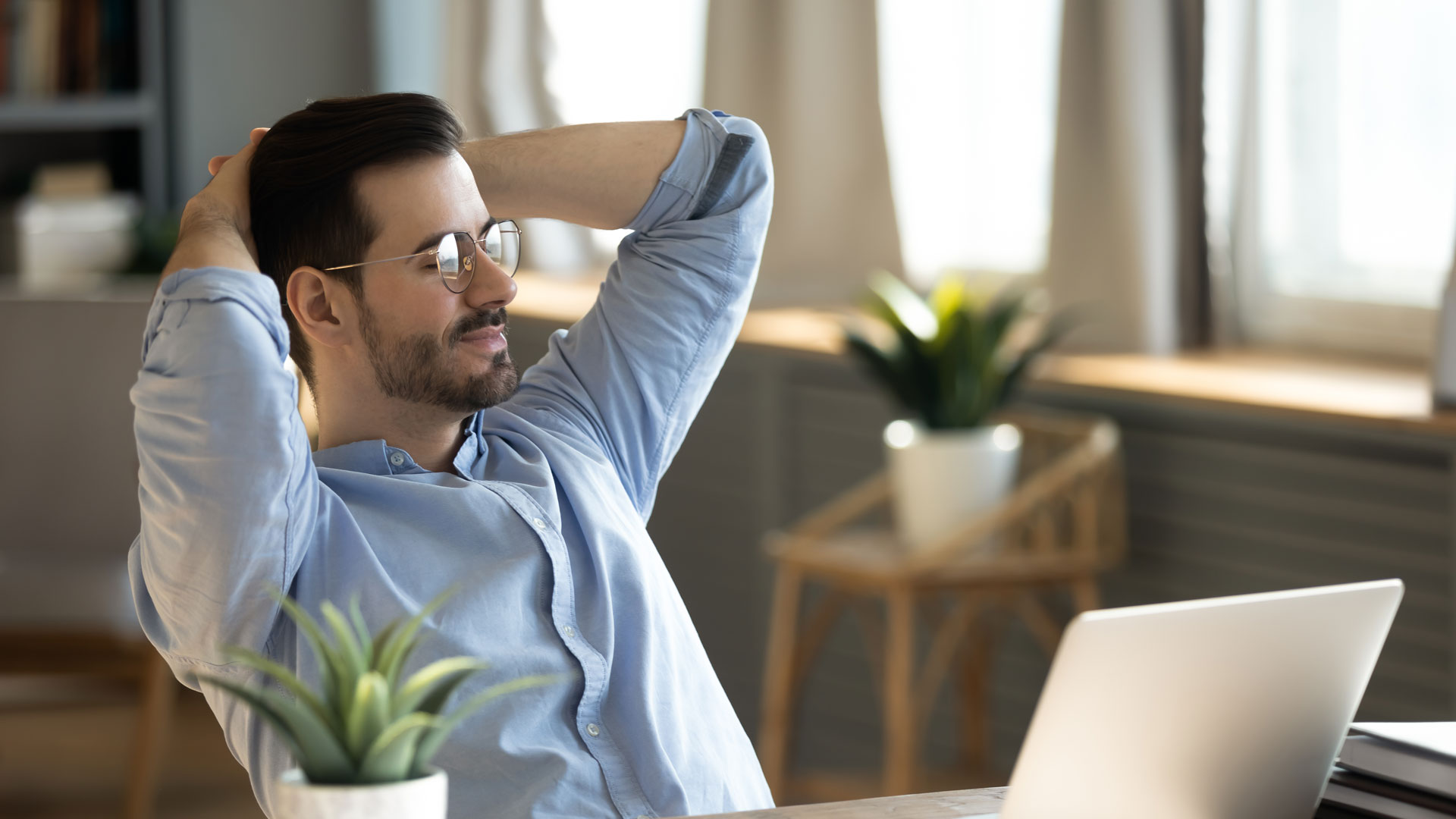 Man relaxing with both arms behind his head