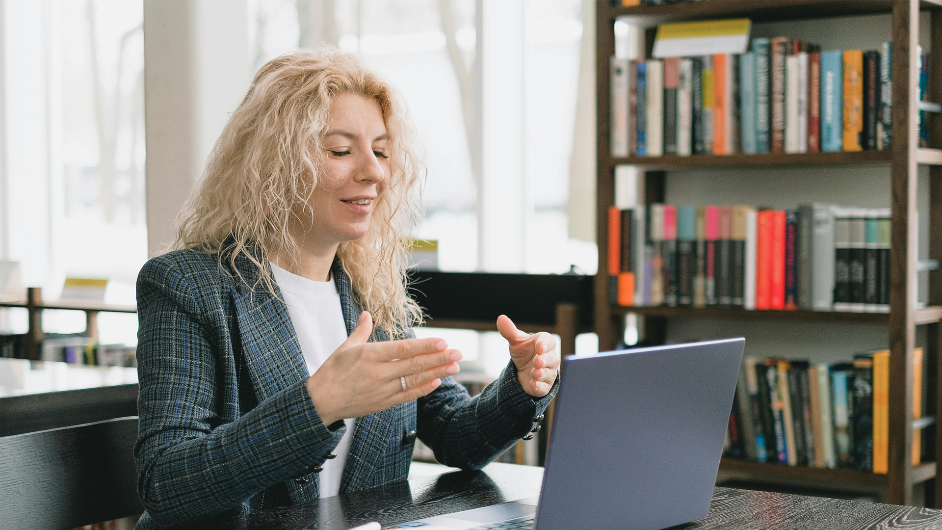 Smiling lady talking with a laptop in front of her