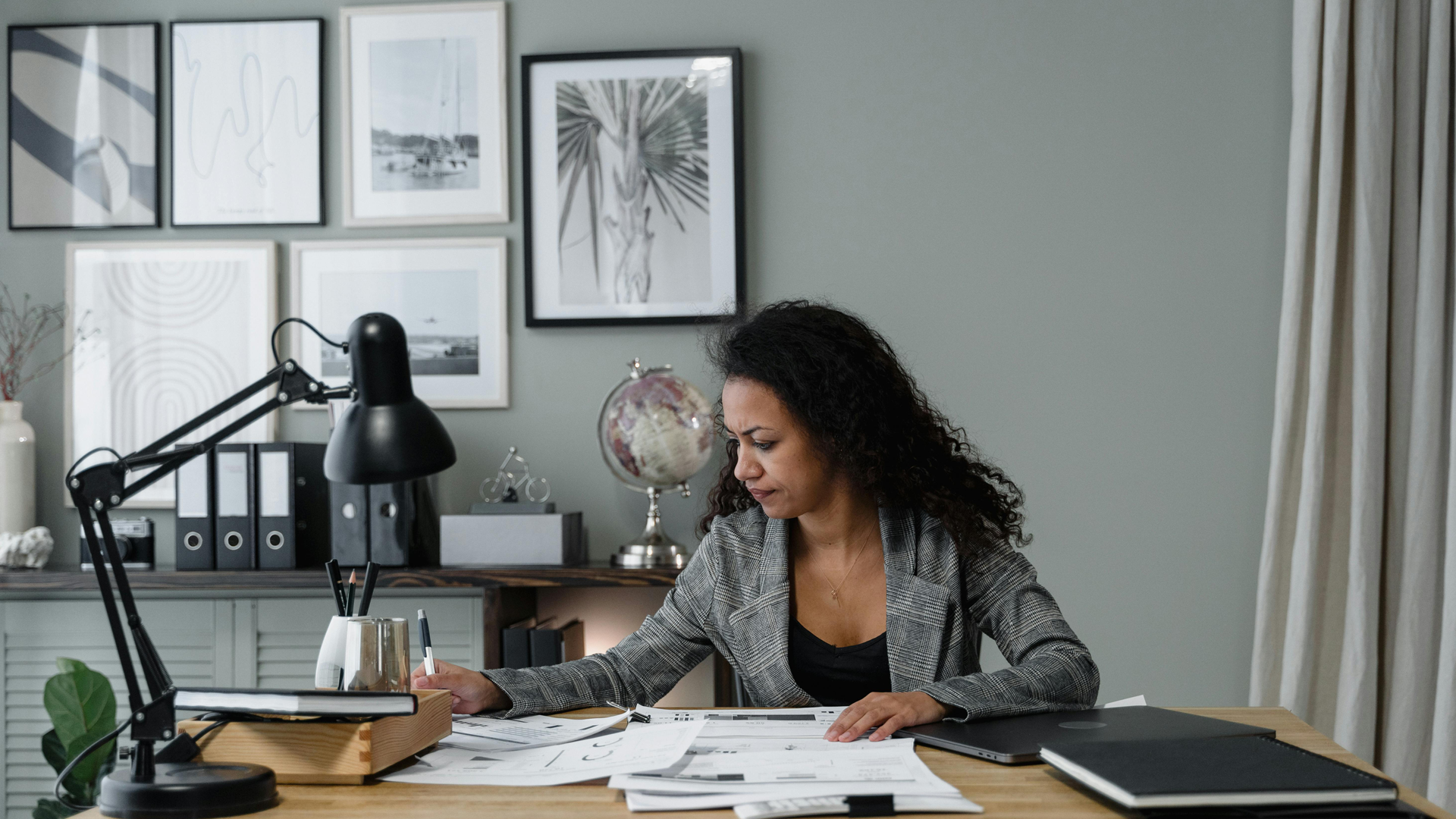 Lady writing on paper with a table filled with papers